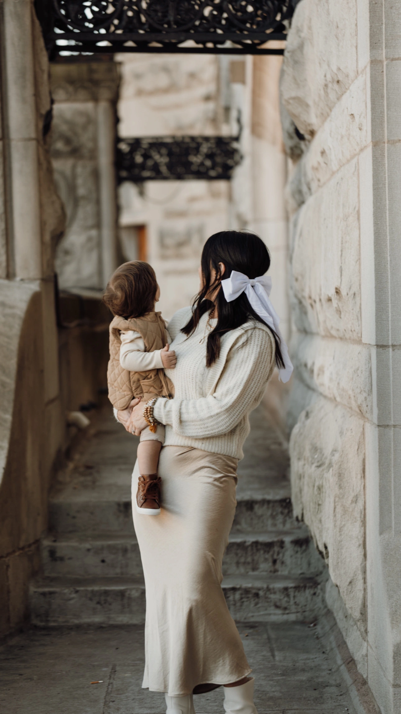 A mother holding her little one beside the stone steps at Union Station in St. Louis